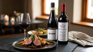 A premium red wine bottle and glass with grapes and cheese on a dark surface.