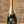 A bottle of Krug Grand Cru Champagne Cuvée Signature, personalized with a monogram and the names 'Chloe & Cyrus' on the label, set on a wooden surface with decorative stones against a rustic stone wall background.